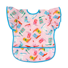 Load image into Gallery viewer, Bumkins Ruffle Apron Bib: Boots features pink waterproof fabric with a cowboy boot pattern, ruffle sleeves, blue trim, and front pocket.
