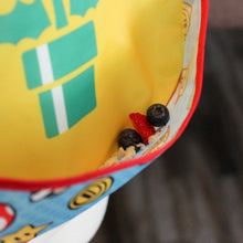 Load image into Gallery viewer, Close-up of berries in the pocket of a Bumkins SuperBib® 2 Pack: Super Mario™.

