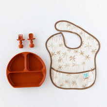 Load image into Gallery viewer, A palm tree Bumkins SuperBib® 3 Pack: Palms + Check, rust-colored plate, and two matching utensils are displayed on a white background.
