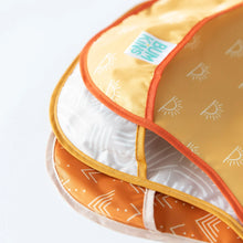 Load image into Gallery viewer, Close-up of Bumkins SuperBib® 3 Pack: Desert Boho stacked on a white background, with focus on the catch-all pocket.
