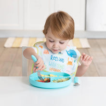 Load image into Gallery viewer, A toddler eats from a blue divided plate with a fork, wearing a Bumkins SuperBib® 3 Pack: Rolling With the Waves.
