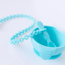 Load image into Gallery viewer, A Bumkins Silicone Accessory Tether 2-Pack: Blue is attached to a blue spoon in a blue bowl on a white background.
