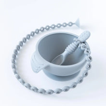 Load image into Gallery viewer, A Bumkins Silicone Accessory Tether 2-Pack: Gray is attached to a gray spoon in a gray bowl on a white background.
