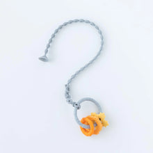 Load image into Gallery viewer, A Bumkins Silicone Accessory Tether 2-Pack: Gray attached to an orange and gray teething toy on a white background.
