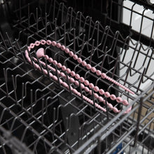 Load image into Gallery viewer, Bumkins Silicone Accessory Tether 2-Pack: Pink sits in the top rack of an open dishwasher.
