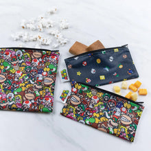 Load image into Gallery viewer, Bumkins Reusable Snack Bag, 3-Pack: Super Mario™ Power Up lays on a marble surface with snacks like popcorn, cookies, and cheese cubes.
