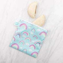 Load image into Gallery viewer, Two crustless sandwich halves spill from a blue Bumkins Reusable Snack Bag, Large 2-Pack: Rainbows &amp; Unicorns on a marble surface.
