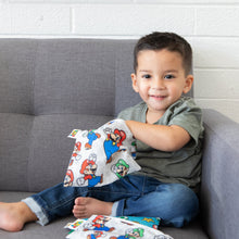 Load image into Gallery viewer, A smiling child sits on a gray couch, reaching into a Bumkins Reusable Snack Bag, Large: Super Mario™ &amp; Luigi.
