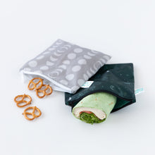Load image into Gallery viewer, Bumkins Reusable Snack Bag, Large 2 Pack: Desert Night lays on a white background, holding a wrap and pretzels.
