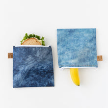 Load image into Gallery viewer, Roamio by Bumkins Reusable Snack Bag, Large 2 Pack: Denim on Denim holds a sandwich and a banana on a white background.
