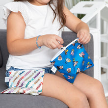Load image into Gallery viewer, A child wearing a white shirt on a couch zips Bumkins Reusable Snack Bag, Large 2 Pack: Mickey &amp; Friends MVP.
