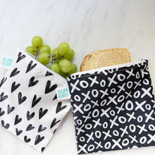 Load image into Gallery viewer, On a marble surface, Bumkins Reusable Snack Bag, Large 2-Pack: XOXO &amp; Hearts holds grapes and a sandwich.
