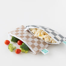 Load image into Gallery viewer, Bumkins Reusable Snack Bag, Small 2 Pack: Double Check holds snacks like popcorn and veggies on a white background.
