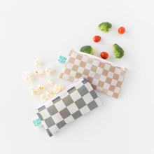 Load image into Gallery viewer, Bumkins Reusable Snack Bag, Small 2 Pack: Double Check amidst broccoli, cherry tomatoes, and popcorn on a white background.
