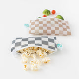 Bumkins Reusable Snack Bag, Small 2 Pack: Double Check overflows with popcorn, broccoli, and cherry tomatoes on a white background.
