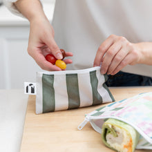 Load image into Gallery viewer, Hands place tomatoes into a Roamio by Bumkins Reusable Snack Bag, Small 2 Pack: Motley Club on a cutting board next to a bag with a wrap.
