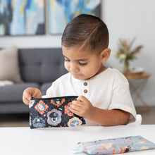 Load image into Gallery viewer, A young boy looks into a Bumkins Reusable Snack Bag, Small 2 Pack: Everyday Is Halloween at a white table in a modern living room.
