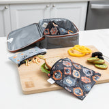 A Bumkins Reusable Snack Bag, Small 2 Pack: Everyday Is Halloween sits on a cutting board on a kitchen counter with food next to a lunch bag.