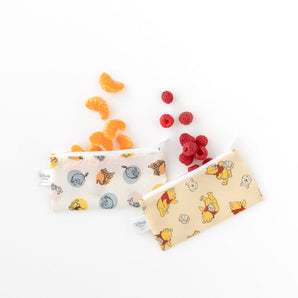 Bumkins Reusable Snack Bag, Small 2 Pack: Pooh Bear and Friends with tangerines and raspberries on a white background.
