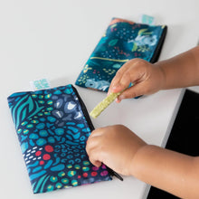Load image into Gallery viewer, Close-up of a child holding a snack near Bumkins Reusable Snack Bag, Small 2-Pack: Jungle &amp; Animal Prints on a white table.
