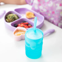 Load image into Gallery viewer, Bumkins Silicone Straw Cup with Lid: Blue sits on a white table in front of a purple sectioned plate of food.
