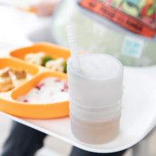 Load image into Gallery viewer, Close-up of a Bumkins Silicone Straw Cup with Lid: Gray on a white high chair tray next to an orange sectioned plate of food.
