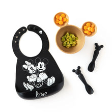 Load image into Gallery viewer, Bumkins Silicone Dipping Spoons: Mickey Mouse (Classic Black) lays next to a black bib and a gold bowl with food on a white background.
