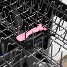 Load image into Gallery viewer, Bumkins Silicone Dipping Spoons: Minnie Mouse (Black and Pink) sit in the top rack of an open dishwasher.
