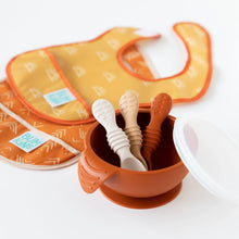 Load image into Gallery viewer, Bumkins Silicone Dipping Spoons 3 Pack: Rocky Road sits in an orange bowl on a white background, with two bibs blurred behind.

