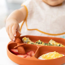 Load image into Gallery viewer, Close-up of a child using Bumkins Silicone Chewtensils®: Clay to pick up strawberries from a divided plate with scrambled eggs and yogurt.
