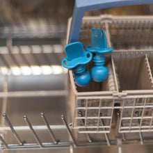 Load image into Gallery viewer, Bumkins Silicone Chewtensils®: Dark Blue sits in the utensil compartment of an open dishwasher.
