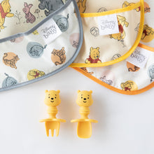 Load image into Gallery viewer, Close-up of 3 colorful printed bibs above Bumkins Silicone Chewtensils®: Winnie The Pooh on a white background.
