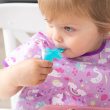 Load image into Gallery viewer, Close-up of a child in a purple unicorn bib chewing a Bumkins Silicone Chewtensils®: Blue Jelly.
