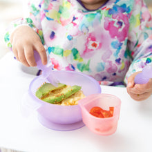 Load image into Gallery viewer, A child in a colorful bib enjoys avocado and rice from a purple bowl with Bumkins Silicone Chewtensils®: Purple Jelly, plus a cup of tomatoes.
