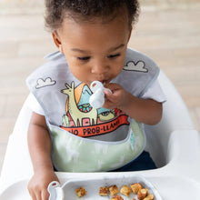 Load image into Gallery viewer, A toddler in a high chair, wearing a llama bib, holds a Bumkins Silicone Chewtensils®: Marble in their mouth; a plate of food sits in front.
