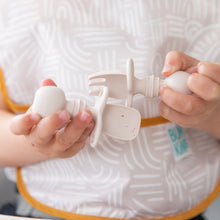Load image into Gallery viewer, Close-up of a child exploring baby-led weaning with Bumkins Silicone Chewtensils®: Sand, featuring sensory bumps for an engaging mealtime.
