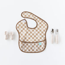 Load image into Gallery viewer, Bumkins Silicone Chewtensils®: Sand sit to the left of a tan checkered bib on a white background., with another set of utensils to the right.
