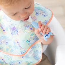 Load image into Gallery viewer, Close-up of a toddler wearing a pastel bib in a high chair with a Bumkins Spoon + Fork: Stitch in their mouth.
