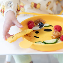 Load image into Gallery viewer, Close-up of a child's hand reaching for a Bumkins Spoon + Fork: Winnie the Pooh on a Winnie the Pooh-shaped plate with fruit &amp; veggies.
