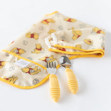 Load image into Gallery viewer, Bumkins Spoon + Fork: Pineapple lays near a folded yellow sleeved bib on a white background.
