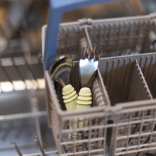 Load image into Gallery viewer, Bumkins Spoon + Fork: Sage sits in the utensil compartment of an open dishwasher.
