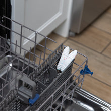 Load image into Gallery viewer, Bumkins Spoon + Fork: Vanilla Sprinkle sits in the utensil compartment of an open dishwasher.
