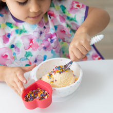 Load image into Gallery viewer, A child happily eats ice cream and sprinkles from a bowl with Bumkins Spoon + Fork: Vanilla Sprinkle at a white table.
