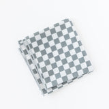 A folded Bumkins Splat Mat: Charcoal Check lays on a white background.