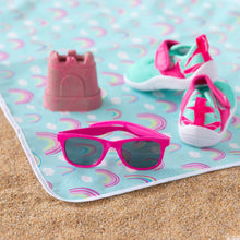 Load image into Gallery viewer, Close-up of Bumkins Splat Mat: Rainbows on sand, with water shoes, pink sunglasses, and a toy on top.

