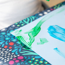 Load image into Gallery viewer, Close-up of a painted piece of paper on a Bumkins Splat Mat: Animal Prints.

