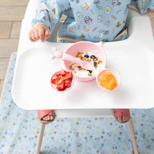 Load image into Gallery viewer, A toddler in patterned bib sits at a high chair with fruit, yogurt, and granola on a Bumkins Splat Mat: Mickey + Minnie Sunny Side Up.
