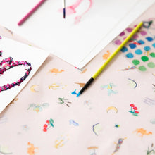 Load image into Gallery viewer, Close-up of colorful artwork and paintbrushes on Bumkins Splat Mat: Princess Magic.
