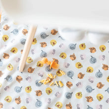 Load image into Gallery viewer, Bumkins Splat Mat: Winnie and Friends lays under a high chair, with an orange baby fork and mac &amp; cheese on top. 
