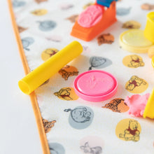 Load image into Gallery viewer, Close-up of colorful modeling clay tools and shapes on Bumkins Splat Mat: Winnie and Friends on a white background.
